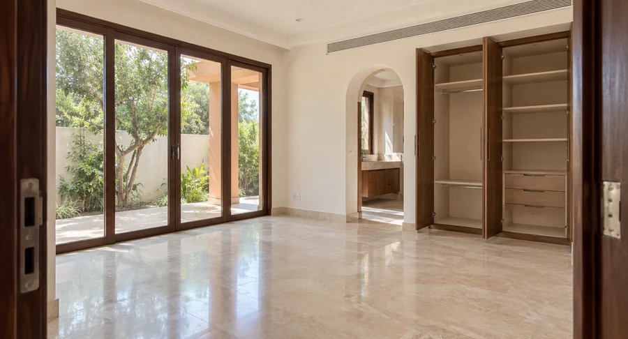 Empty clean room with open wardrobe and sliding glass doors after professional move-out cleaning service