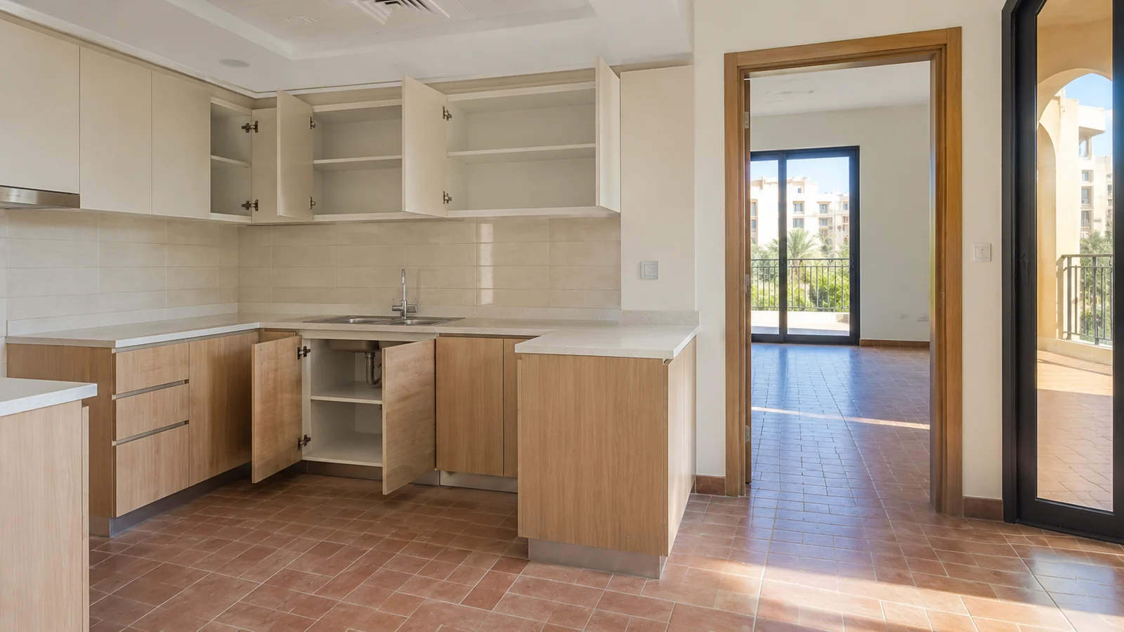 Spotless empty kitchen with open cabinets and tiled floors after professional specialized cleaning service
